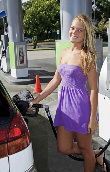 stock image Beautiful teenage girl putting gas into her car