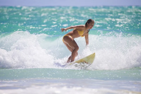 Mädchen im gelben Bikini beim Surfen — Stockfoto