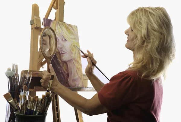 Rtist in her fifties painting a self portrait — Stock Photo, Image