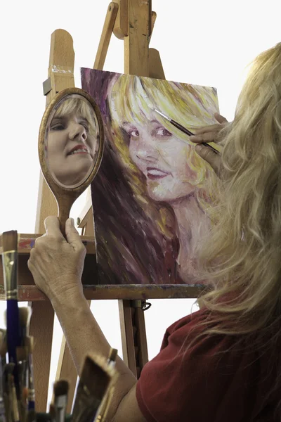 Künstlerin in den Fünfzigern beim Malen eines Selbstporträts — Stockfoto