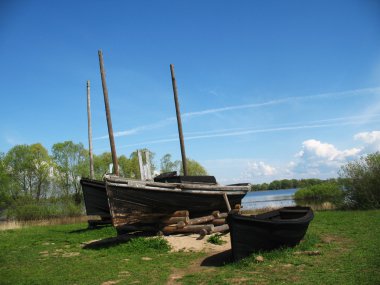 Ancient fishermens boats on the coast clipart