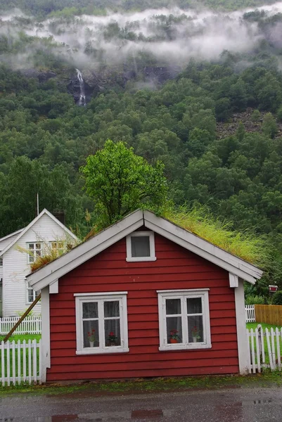 Červený domek s trávy střeše — Stock fotografie
