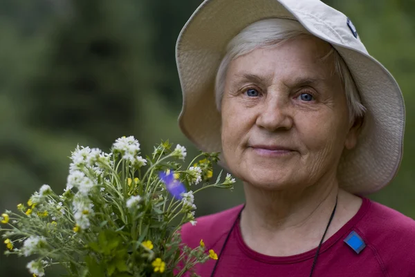 Old women with flowers — Stock Photo, Image