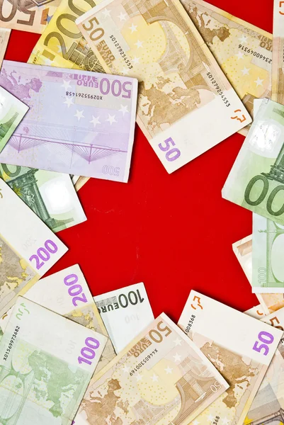 Euro bills and star on red background — Stock Photo, Image