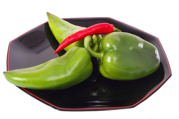 Tres pimientos verdes y chile rojo en el plato negro —  Fotos de Stock