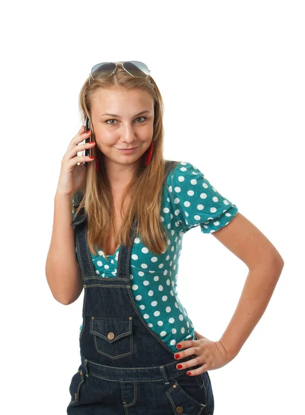 Den unga flickan talar av en mobiltelefon Stockbild