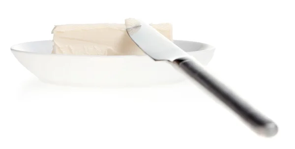 Stukje boter op een schotel en mes — Stockfoto