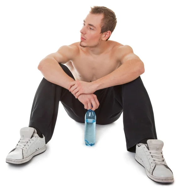 Young man with a bottle of clear liquid — Stock Photo, Image