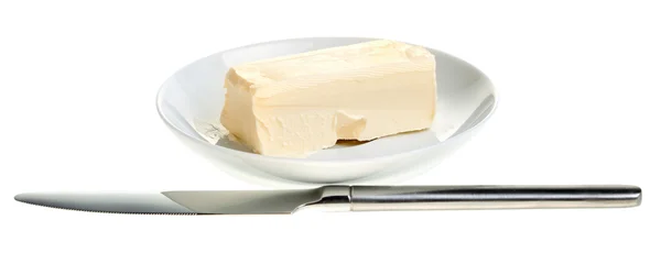 Piece of butter on a saucer and knife — Stock Photo, Image