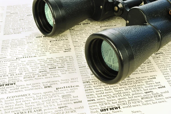 Black binoculars and news — Stock Photo, Image