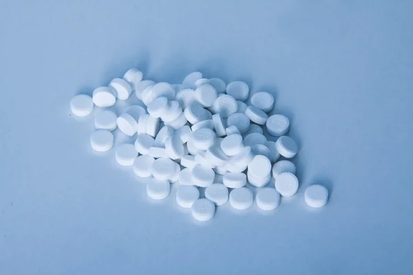 Fehér tabletták kék háttér — Stock Fotó