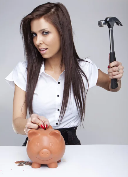 Young woman breaking a piggy bank — Stock Photo, Image