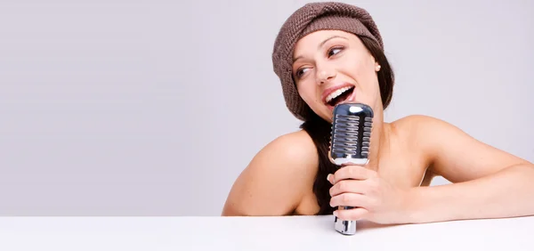 Сексуальная девушка, поющая в ретро-микрофоне — стоковое фото