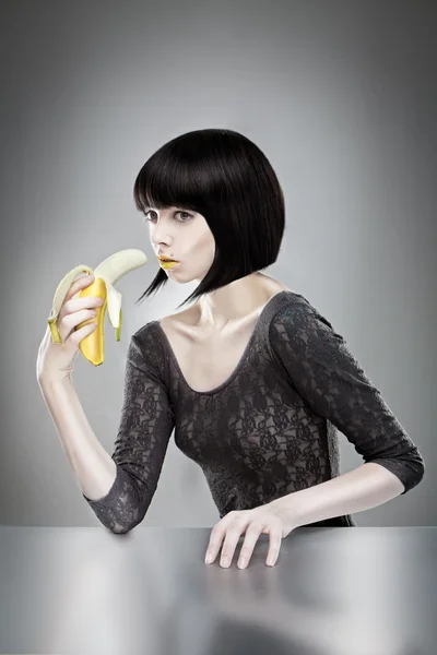 Morena sosteniendo plátano —  Fotos de Stock