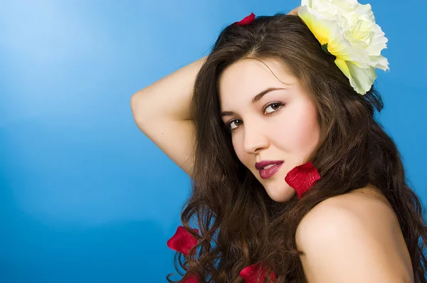 Schönes Mädchen in roten Blütenblättern — Stockfoto