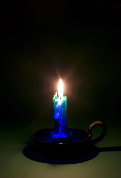 Палаюча свічка на зеленому фоні — стокове фото