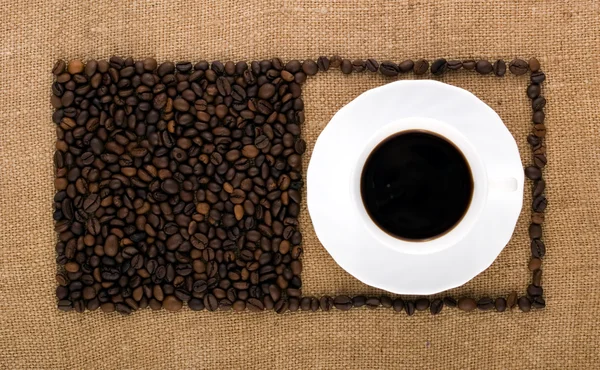 Des carrés de grains de café et une tasse — Photo