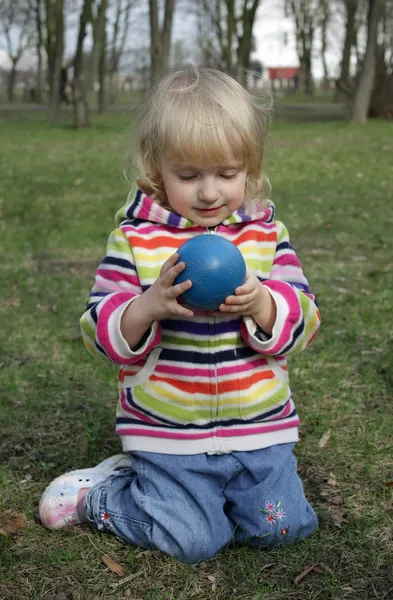 The little girl is considering a ball — Stock Photo, Image