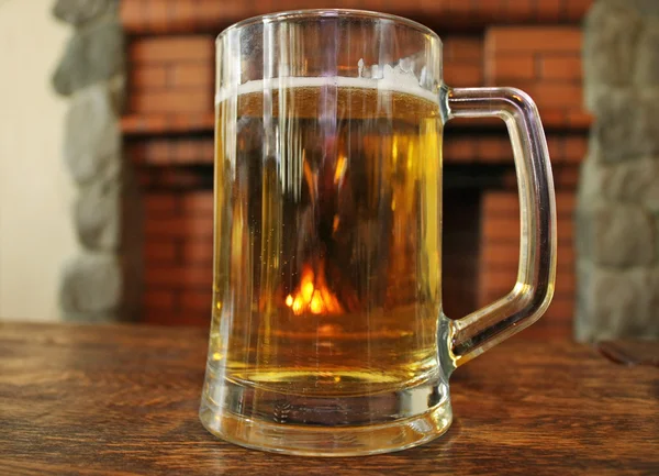 Una taza de cerveza en una mesa de madera —  Fotos de Stock