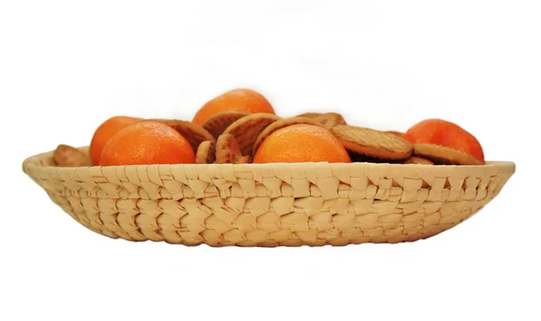Mandarins and biscuits on a wicker plate — Stock Photo, Image