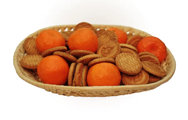 Mandarins and biscuits on a wicker plate — Stock Photo, Image