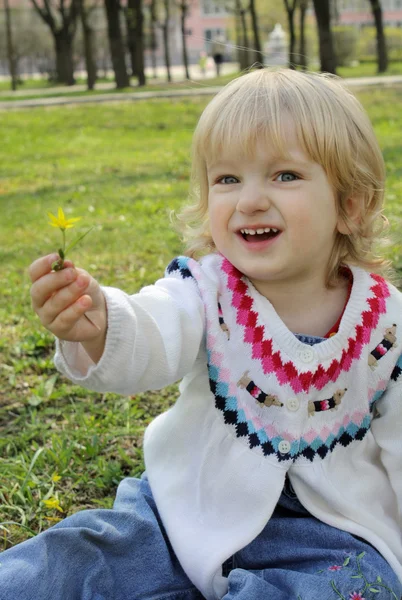 Een klein meisje geeft een bloem — Stockfoto