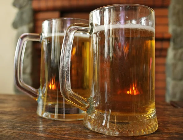 Dos tazas de cerveza en una mesa de madera —  Fotos de Stock