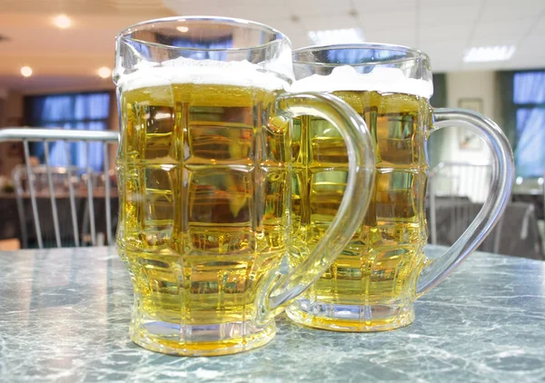 Dos tazas de cerveza en una mesa —  Fotos de Stock