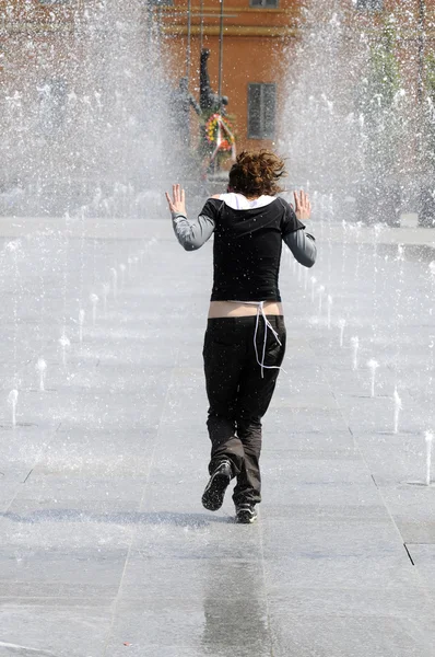 stock image Young girl running under the water