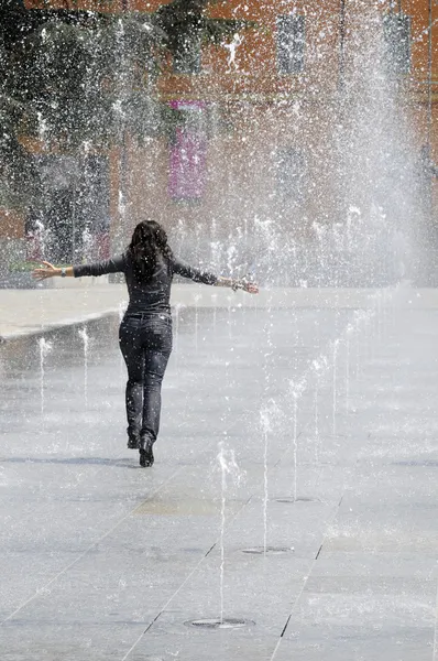 stock image Young girl running under the water