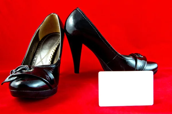 Black shoes and card on red background — Stock Photo, Image