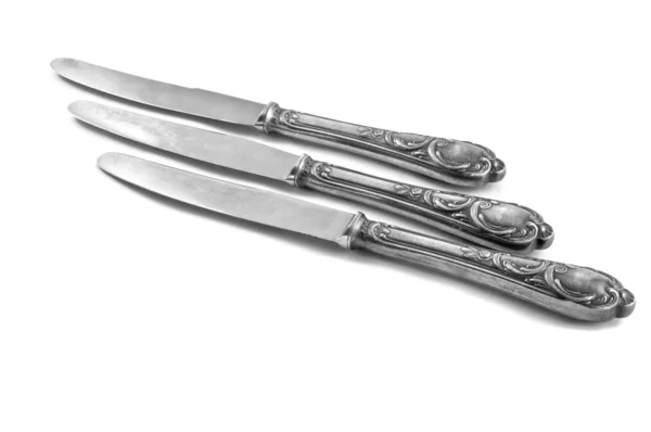 Tre bord knivar på vit bakgrund Stockfoto
