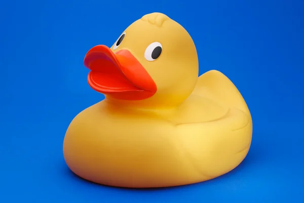 Mavi arkaplanda sarı plastik ördek — Stok fotoğraf