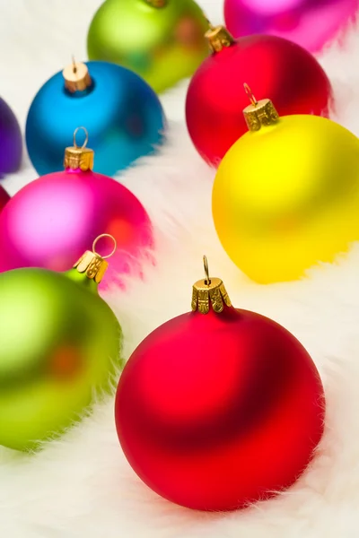 Many Christmas baubles on white fur — Stock Photo, Image