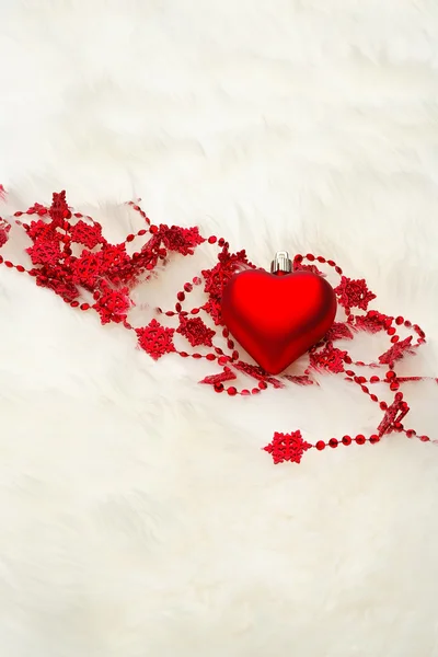 Красное сердце на белом мехе — стоковое фото