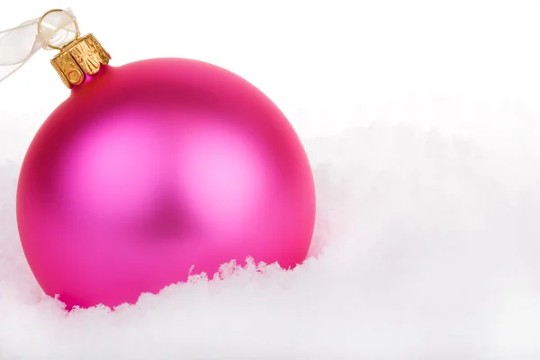 Roze Kerstbal op sneeuw — Stockfoto