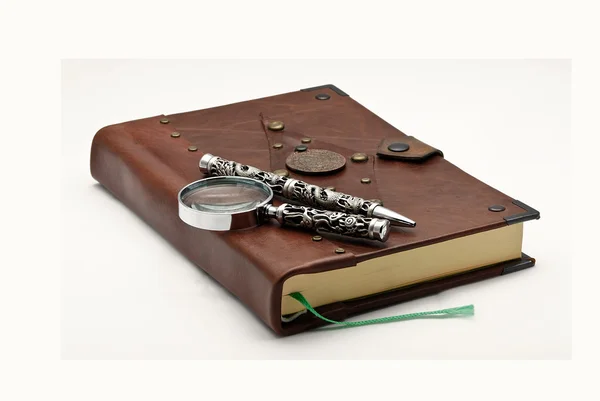 Livro velho com uma caneta e lupa — Fotografia de Stock