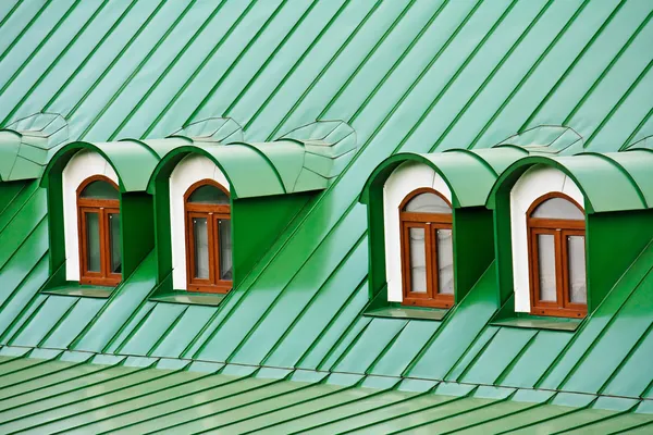 Dormers στεγών στη στέγη που καλύπτεται με πλάκες σιδήρου πράσινο — Φωτογραφία Αρχείου