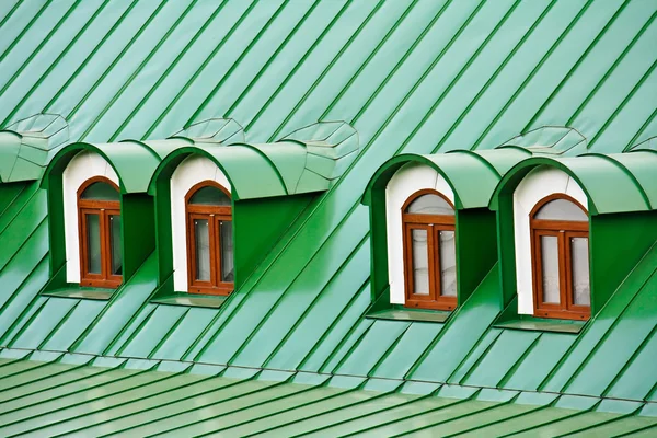Telhado dormers no telhado coberto com placas de ferro verde Imagens De Bancos De Imagens