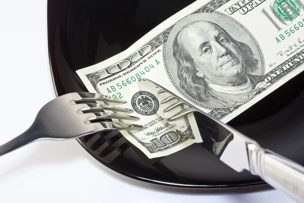 Banknote on a black plate with knife and fork — Stock Photo, Image