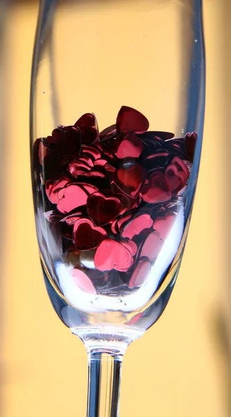 Confetti a forma di cuore in un'influenza champagne — Foto Stock