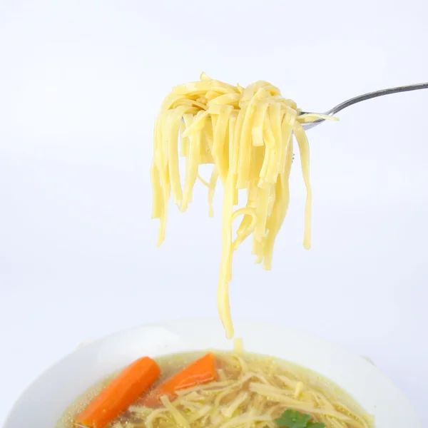 Куриный суп с макаронами немного на ложке — стоковое фото