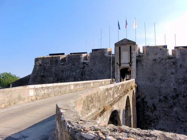 Puerta de la antigua fortaleza con banderas Fotos De Stock