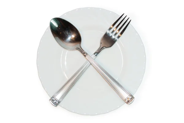 Forchetta e cucchiaio incrociati su piatto — Foto Stock