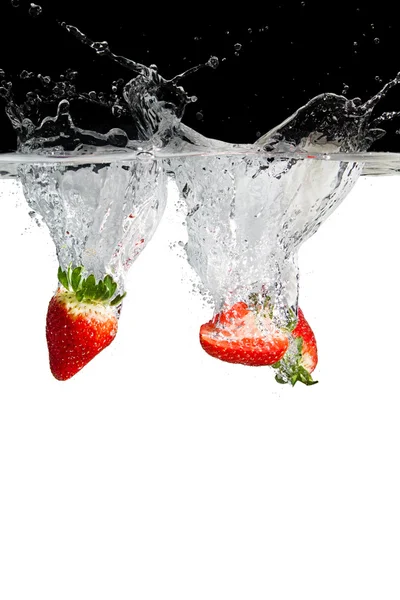 在水中的三个草莓件 — 图库照片
