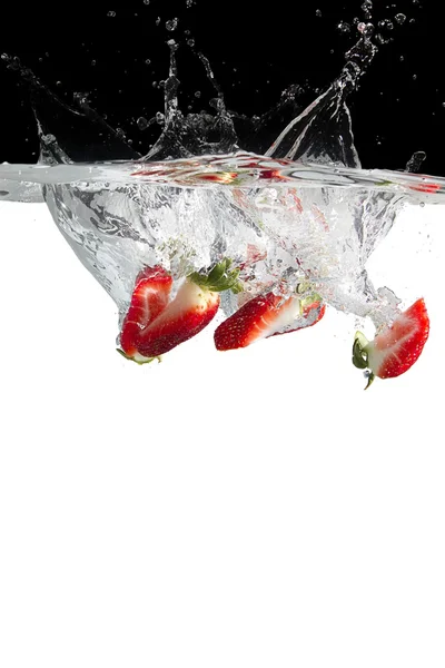 Some strawberry pieces in water — Stock Photo, Image