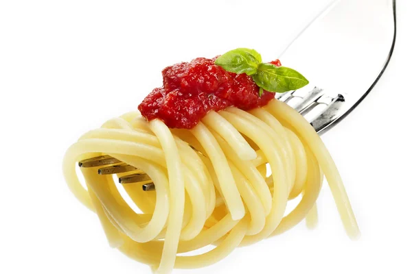 Pasta con salsa y albahaca en un tenedor Imagen de stock