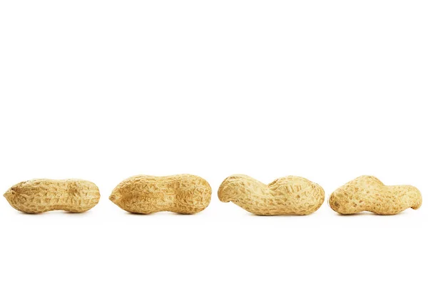 Four peanuts in a row — Stock Photo, Image