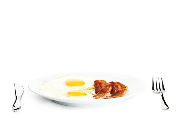 Жареные яйца и бекон на тарелке — стоковое фото