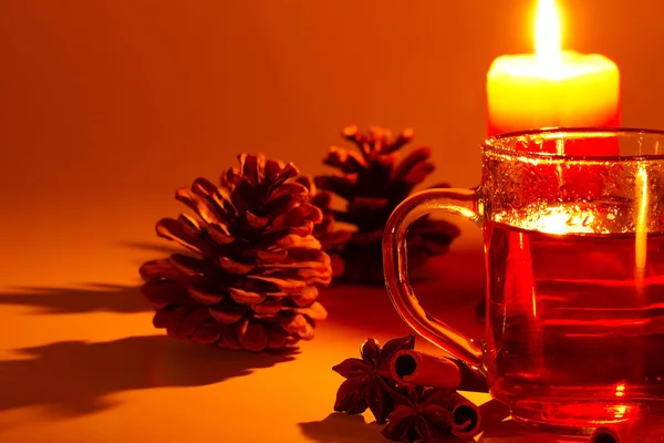 Rött te kanelstänger stjärnanis conifer kon på levande ljus — Stockfoto